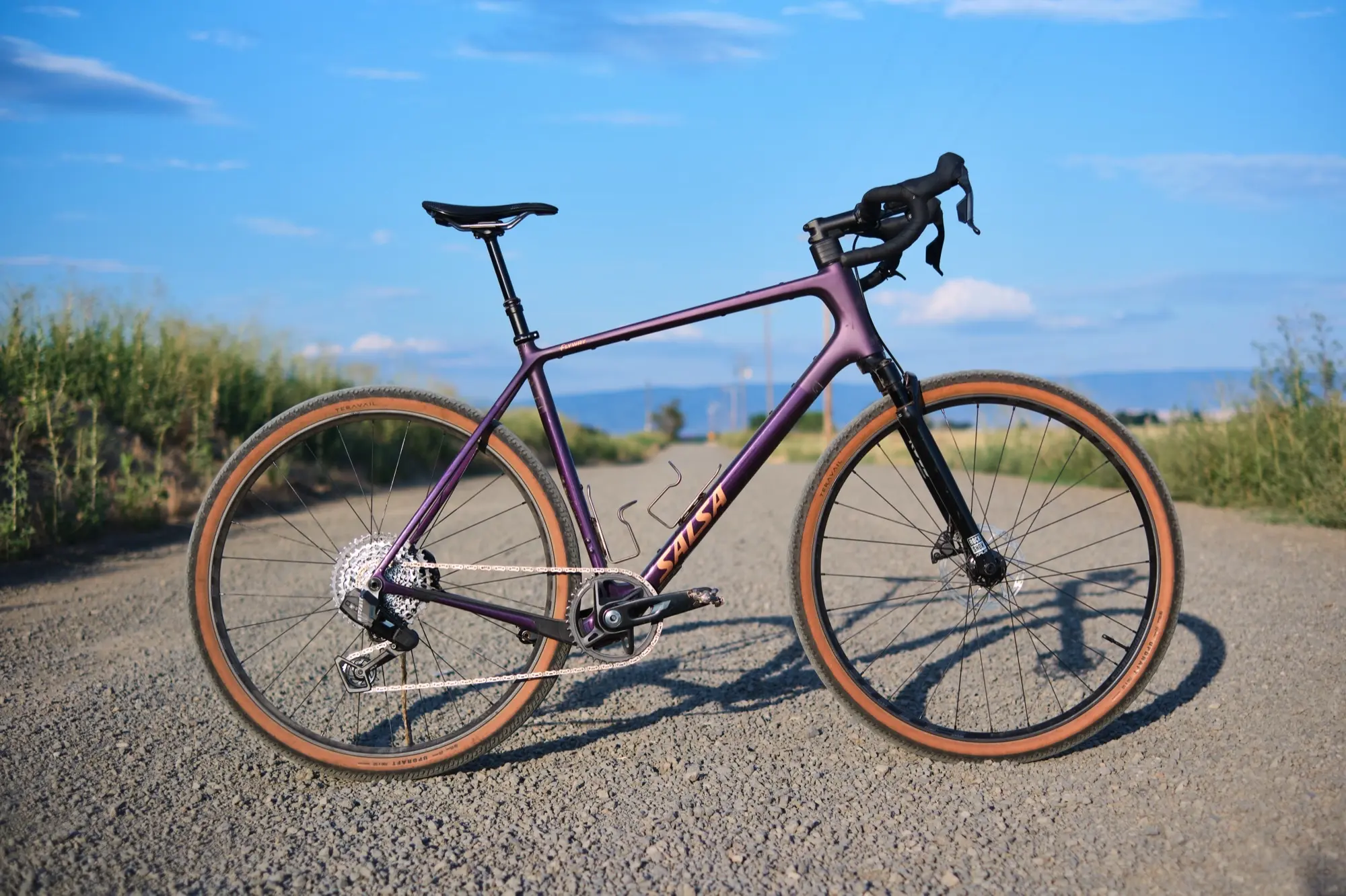 The Flyway C XPLR in profile on an empty gravel road under a big sky